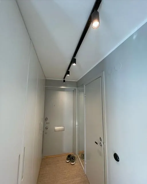 Ljus hall med svarta spotlights på en takskena